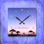 Op Beach Time California Paars Pink Sunset Foto Vierkante Klok<br><div class="desc">"Op het strand." Een paarse blauwe en roze zonsondergang op een strand in Zuid-Californië met gebarsten palapas zorgt voor ontspanning en reflectie. Relax, ruik de oceaanlucht, en herinner herinneringen aan de zomer wanneer je de tijd op deze stijlvolle, fotografische muurklok controleert. Uw keuze uit een rond of vierkant klokgezicht. Maakt...</div>