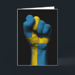 Opgeheven gebalde vuist met Zweedse vlag Kaart<br><div class="desc">Dit krachtige ontwerp van kunstenaar Jeff Bartels toont de vlag van Zweden geschilderd op een gebalde vuist. De hand wordt opgestoken die de schijn van kracht, macht, solidariteit en veerkracht geeft. De vuist is prachtig gedetailleerd en zit voor een achtergrond die kan worden aangepast aan elke kleur die u wilt....</div>