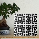 Optische illusie zwart en wit geometrisch patroon tegeltje<br><div class="desc">Moderne decoratieve keramische tegel met een mozaïekpatroon van geometrische witte vormen op een zwarte achtergrond. Textuur met optische illusie-effect.</div>