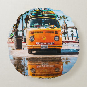Oranje bestelwagen met surfplank bovenaan rond kussen