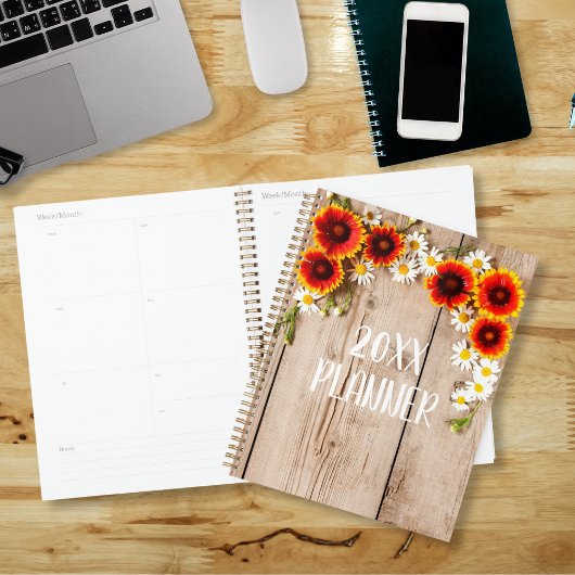 Oranje en gele kamillebloemen op rustiek hout planner