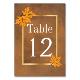 Oranje esdoornbladeren op bruin huwelijkstafelnumm kaart