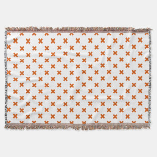 Oranje kruisstiften op wit deken