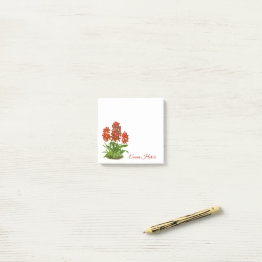 Oranje rode orchidee bloem na het opschrift post-it® notes (Op bureau)