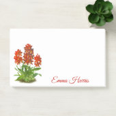 Oranje rode orchidee bloem na het opschrift post-it® notes (Kantoor)
