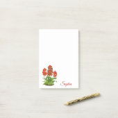 Oranje rode orchidee bloem na het opschrift post-it® notes (Op bureau)