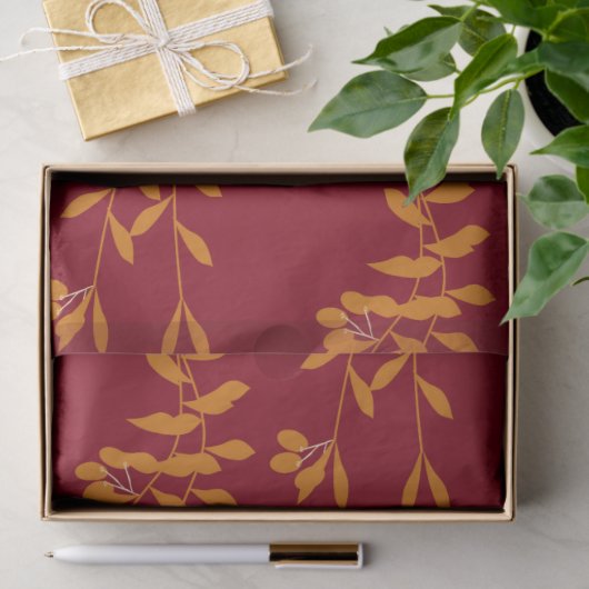 Oranje silhouetbladeren op rood tissuepapier (Geschenk)