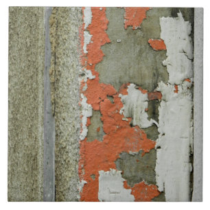 Oranje verf met grunge-schil op betonnen wand tegeltje