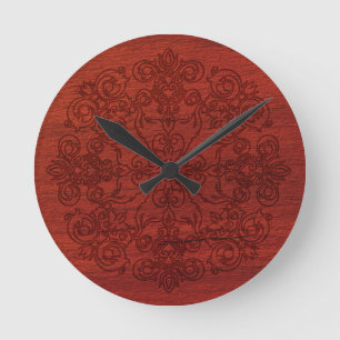 Ornament gegraveerd op rustiek donkerrood hout ronde klok