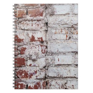 Oud geschilderde bakstenen wand met een witte schi notitieboek
