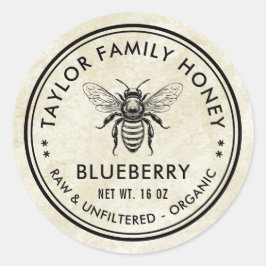 Oud label van blauwe bosbessenhoning met honingbij