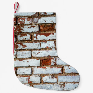 Oude bakstenen wand met gestrooid wit gipsplaat kleine kerstsok