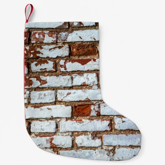 Oude bakstenen wand met gestrooid wit gipsplaat kleine kerstsok (Voorkant)