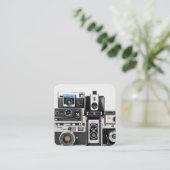 Oude camera collectie gestapeld op wit vierkante visitekaartje (Staand voorkant)