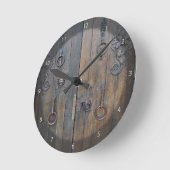 Oude decoratieve houten deur op de stenen wand ronde klok (Hoek)