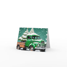 Oude groene vrachtwagen met kerstboom achterin.