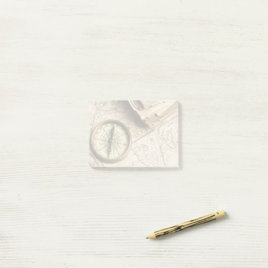 Oude kompas over oude kaart post-it® notes (Op bureau)