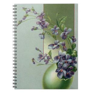 Oude paarse bloemen bloeiend in een paasei notitieboek