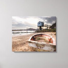 Oude rode roeiboot op het strand met toren canvas afdruk