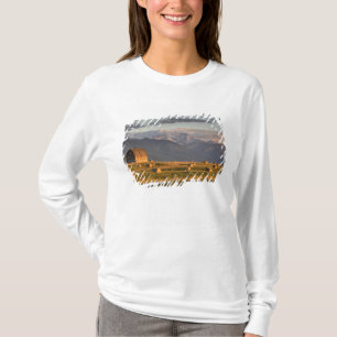 Oude schuur omlijst door hooibalen en dramatisch t-shirt