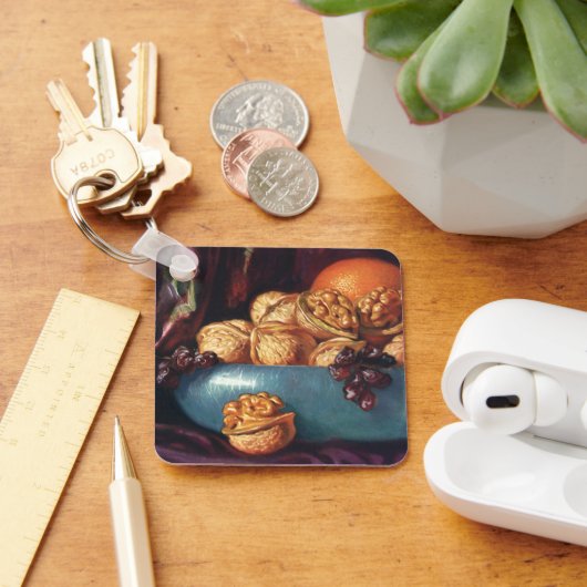 Oude voeding, walnoten en fruit in een blauwe kom sleutelhanger (Bureau)