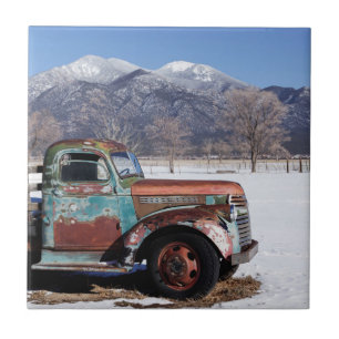 Oude vrachtwagen in het veld tegeltje