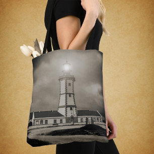 Oude vuurtoren op een stormachtige nacht tote bag