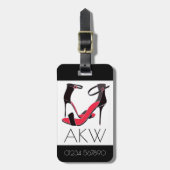 Paar schoenen met hoge hakken op zwart met monogra bagagelabel (Voorkant verticaal)