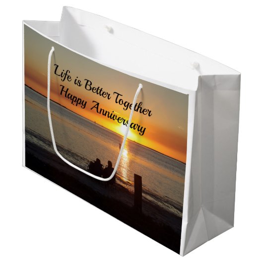 Paar zit op strand bij zonneschijntas groot cadeauzakje (Voorkant Gekanteld)