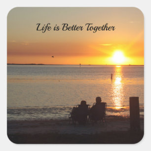 Paar zit op strand bij zonsondergang Stickers