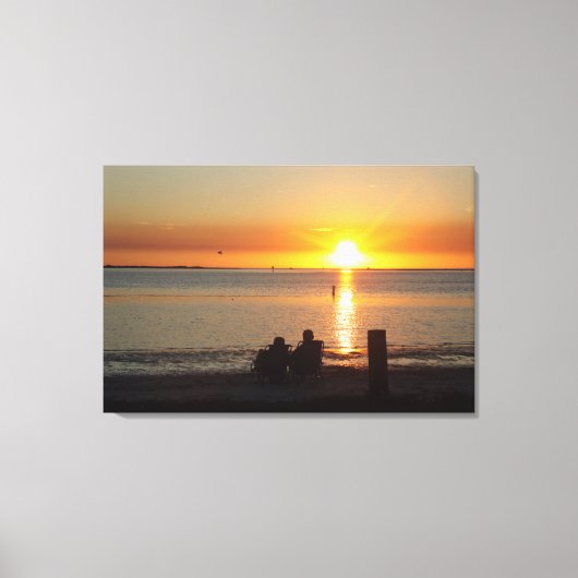 Paar zit op strand op Sunset Canvas print (Voorkant)