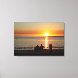 Paar zit op strand op Sunset Canvas print