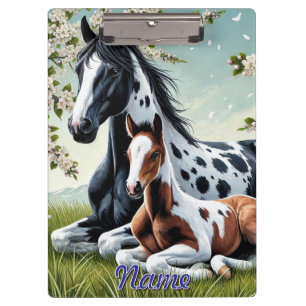 Paard en veulen rusten te midden van bloeiende bom klembord