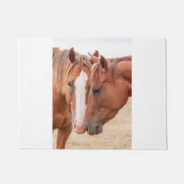Paarden die elkaar in een wei aaien deurmat