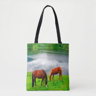 Paarden grazend weiland met een bosmeer tote bag