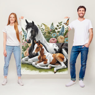 Paarden rusten tussen levendige bloemen en groen fleece deken