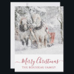 Paarden tijdens de wintervakantie met kerst kaart<br><div class="desc">Serene paarden die slee trekken in de wintersneeuw kerstvakantie-wenskaart. Vrolijk kerstfeest op scripttypografie.</div>