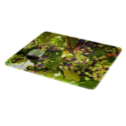 Paarse druiven die op de wijnstok met wijnglas gro snijplank (Hoek)