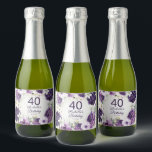 Paarse Floral Glitter 40th Birthday Name Sparkling Wijnetiket<br><div class="desc">Elegante verjaardagsfeestjes op maat mini mousserende wijnflesetiketten voor vrouwen met witte en paarse handgeschilderde bloemen en salie groene bladeren geaccentueerd met gouden glitter. Gepersonaliseerd met haar naam en feestdatum samen met haar leeftijd. Tekst is volledig aanpasbaar en kan worden gewijzigd voor elke gebeurtenis die u plant. Neem contact met mij...</div>