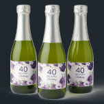 Paarse Floral Glitter 40th Birthday Name Sparkling Wijnetiket<br><div class="desc">Elegante verjaardagsfeestjes op maat mini mousserende wijnflesetiketten voor vrouwen met witte en paarse handgeschilderde bloemen en salie groene bladeren geaccentueerd met gouden glitter. Gepersonaliseerd met haar naam en feestdatum samen met haar leeftijd. Tekst is volledig aanpasbaar en kan worden gewijzigd voor elke gebeurtenis die u plant. Neem contact met mij...</div>