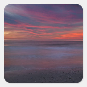 Paarsgekleurde zonsopgang op de oceaanoever vierkante sticker
