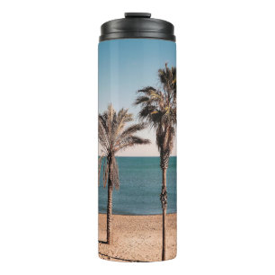Palmboom op het strand in de ochtend thermosbeker