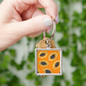 Papaya plakjes op sinaasappel sleutelhanger (Hand)