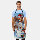 Papillon-hond rent in de sneeuw met kerstmuts schort (Gedragen)