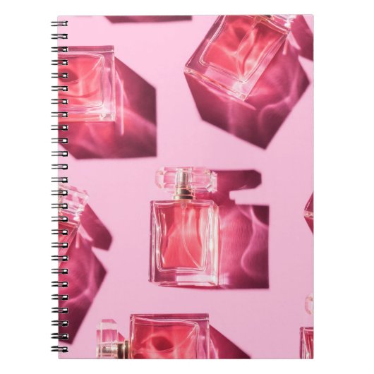 Parfumflessen, roze achtergrond, flatlay notitieboek (Voorkant)
