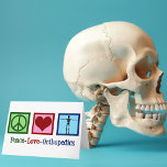 Peace Love Orthopedics Feestdagen Kaart<br><div class="desc">Peace Love Orthopedics cadeau. Een schattig kerstcadeau voor een orthopedische chirurg of orthopedist die werkt met het musculoskeletale systeem en patiënten die een schouder- en heupoperatie nodig hebben. Een vredesteken,  hart en een skelet om de botten van de specialiteit te shows.</div>