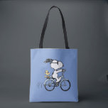 Peanuts | Snoopy & Woodstock Bicycle Tote Bag<br><div class="desc">Pedal into style and classic charm with this adorable cream canvas tote bag, featuring Snoopy and Woodstock on a bicycle! This fun tote showcases a delightful line-art illustration of Snoopy, wearing sunglasses, happily riding a vintage-style blue bicycle with Woodstock perched safely behind him. The dashed lines behind the back wheel...</div>