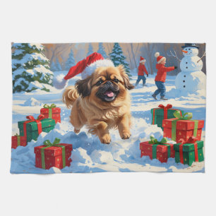 Pekingese hond rent in de sneeuw met kerstmuts theedoek