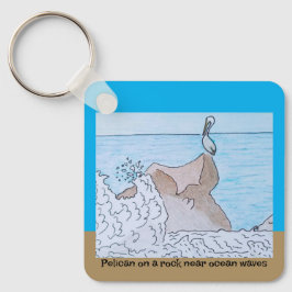 Pelikaan op een rots in de buurt van oceaangolven sleutelhanger
