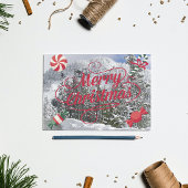 Pepermunt snoepjes en besneeuwd winters landschap feestdagenkaart